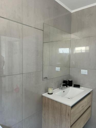 a bathroom with a sink and a mirror at Depto Yrigoyen, opcional COCHERA a 20 metros in Rafaela