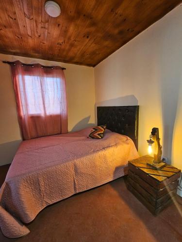 a bedroom with a bed with a red window at Complejo Huayra Huasi in Villa Bustos