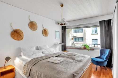 une chambre avec un grand lit et une chaise bleue dans l'établissement Design District w Free Parking Garage, Balcony, Netflix, 200m tram&bus, à Helsinki