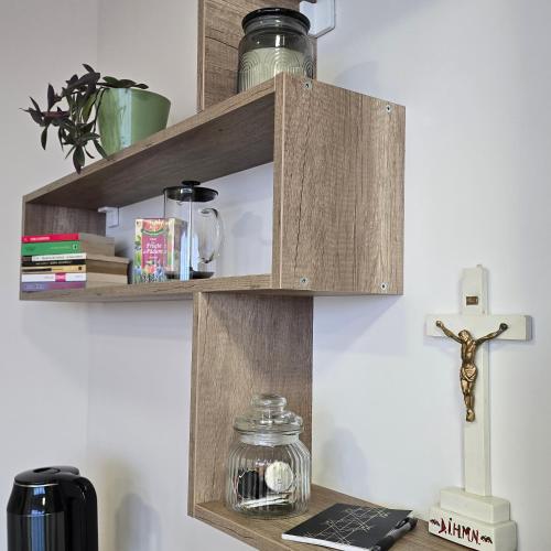 a wooden shelf with a cross on a wall at MA DONNA rooms in Floreşti