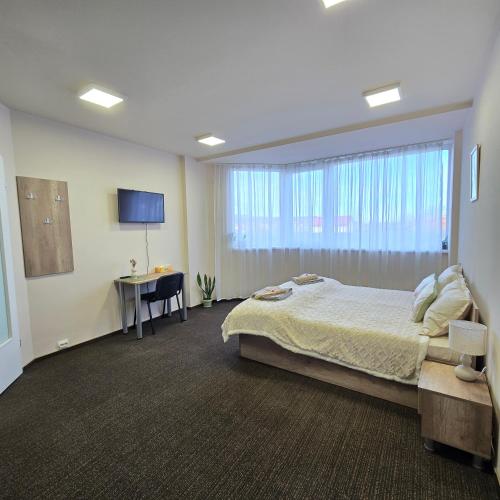 a bedroom with a bed and a window and a desk at MA DONNA rooms in Floreşti