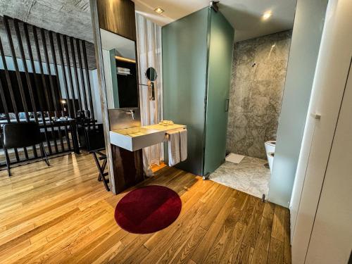 a bathroom with a sink and a red rug at Anselmo Buenos Aires, Curio Collection by Hilton in Buenos Aires