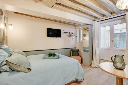 une chambre avec un lit et une télévision au mur dans l'établissement Cozy studio in Le Marais - fully equipped, à Paris