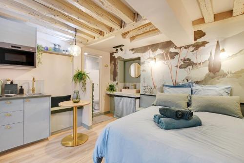 une chambre avec un grand lit blanc et une cuisine dans l'établissement Cozy studio in Le Marais - fully equipped, à Paris