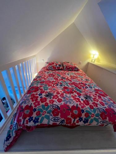 une chambre avec un lit avec une couette fleurie dans l'établissement Studio sur le Port du Crouesty, à Arzon