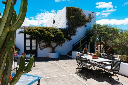 a patio with a table and chairs and a cactus at Hotel Bodega EL GRIFO in San Bartolomé