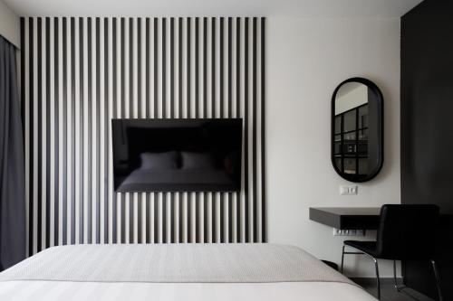 a bedroom with a bed and a mirror and a desk at BOUTiE City Centre in Kalamata