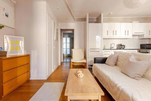 un salon avec un canapé blanc et une table dans l'établissement La Suite Saint-Germain, à Paris