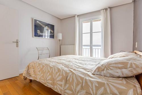 une chambre blanche avec un lit et une fenêtre dans l'établissement La Suite Saint-Germain, à Paris