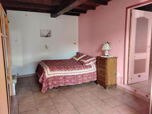 una camera con letto e lampada su un comò di Maison familiale a Médis