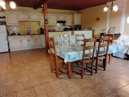 une salle à manger avec une table et des chaises dans une cuisine dans l'établissement Maison familiale, à Médis