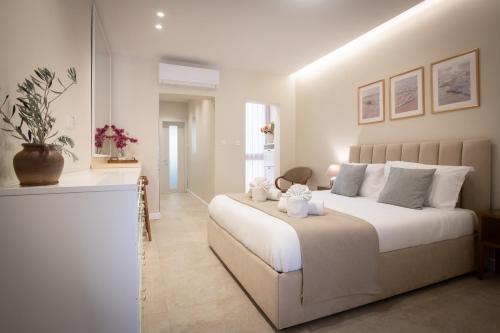 a bedroom with a large white bed with two stuffed animals on it at Sea Salt Studio in Marsalforn