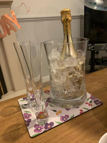 a bottle and two glasses sitting on a table at Katie's Flat in Oban