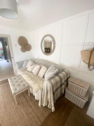 a room with a bed and a mirror and a table at Charming One Bed Cottage in Historic Market Town in Romsey