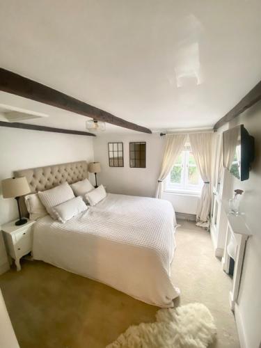 a bedroom with a white bed and a window at Charming One Bed Cottage in Historic Market Town in Romsey