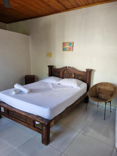 a bedroom with a wooden bed and a chair at Kenith ALTO DEL ROSARIO HONDA in Honda