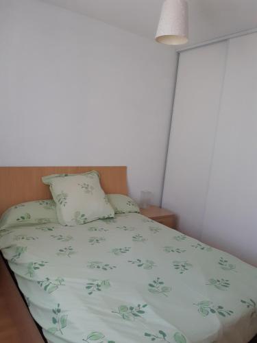 - un lit avec un couvre-lit vert et un oreiller dans l'établissement T3 plain pied jardin privatif, à Saligos