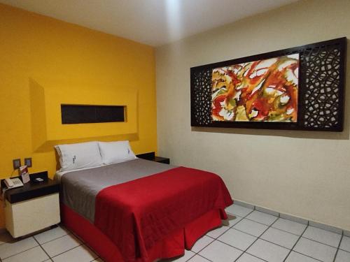 a bedroom with a bed and a painting on the wall at HOTEL MORELOS in Guadalajara