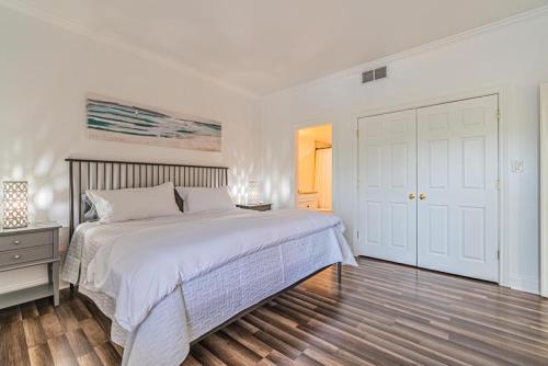1 dormitorio blanco con 1 cama y suelo de madera en 7135 Harbourside II In the heart of dining and shopping Harbour View Sleeps 4 Shelter Cove, en Hilton Head Island