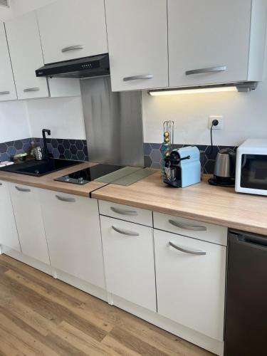 une cuisine avec des armoires blanches et un comptoir dans l'établissement Volt Air Roof Top - Wifi - Parking privé - Proche Gare, à Troyes