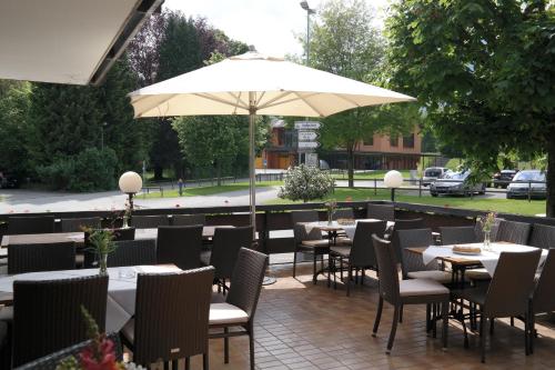 a restaurant with tables and chairs and an umbrella at Landgasthof Rössle ** Superior in Ruggell