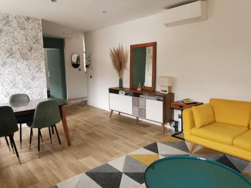 un salon avec un canapé jaune et une table dans l'établissement Appartement Gourette, à Eaux-Bonnes