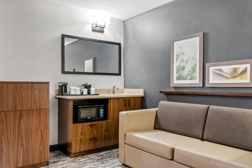 a living room with a couch and a mirror at Country Inn & Suites by Radisson, Winnipeg, MB in Winnipeg