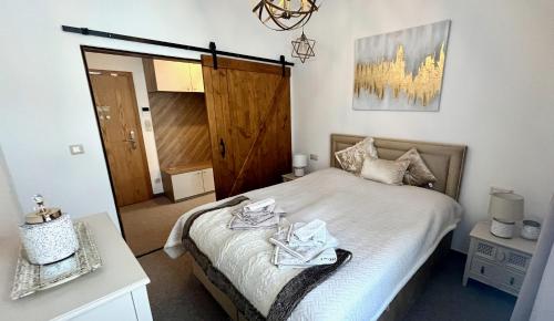 a bedroom with a bed with two towels on it at Vila Kollár - Veverička in Vysoké Tatry