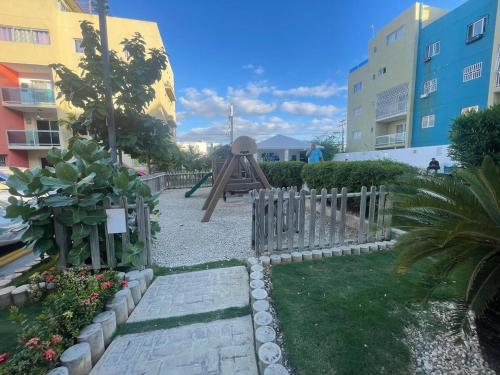 ein Garten mit Holzzaun und Spielplatz in der Unterkunft Apartamento en Edificio Palmares in La Romana