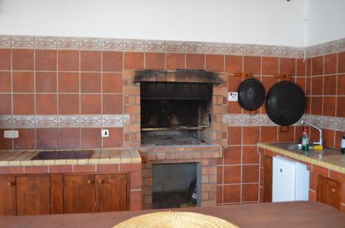 a kitchen with a brick fireplace with pots and pans at Villa Mónica by Mirador de Sotavento Apartments in Cardón