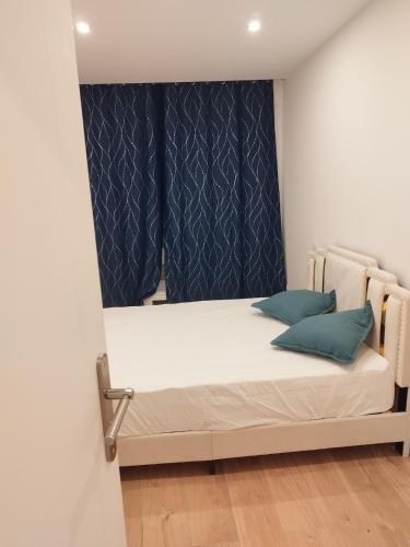 un petit lit dans une chambre avec une fenêtre dans l'établissement Appartement Cosy, Nantes-St-Herblain, à Saint-Herblain