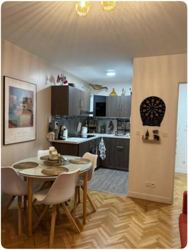 une cuisine et une salle à manger avec une table et des chaises dans l'établissement Appartement de vacance, à Montévrain