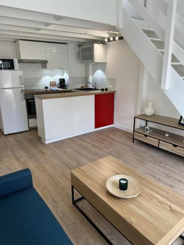 un salon avec une table et une cuisine dans l'établissement Cosy apartment in city center, à Palaiseau