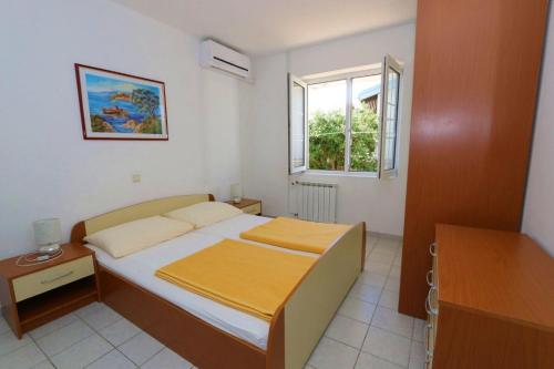 a small bedroom with a bed and a window at Apartments Vacation Jakisnica in Jakišnica