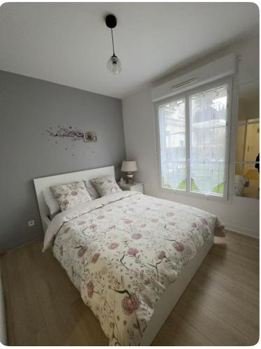 une chambre avec un grand lit et une fenêtre dans l'établissement Appartement de vacance, à Montévrain