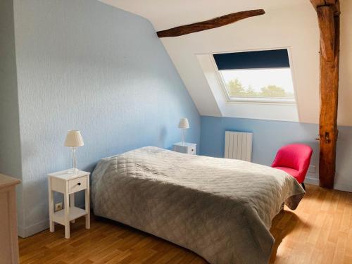 une chambre avec un lit et une chaise rouge dans l'établissement Le gite d Henri, à La Flèche