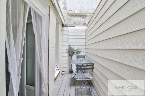 d'une terrasse avec une table et une fenêtre. dans l'établissement Bel appartement avec terrasse, à Clichy