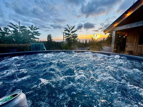 a hot tub with water in it with a sunset in the background at Świerkowa Oaza in Istebna