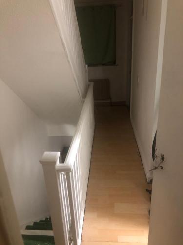 a stairway with white railings and wooden floors at Amazing New Bed Stay in New Cross Goldsmiths in London