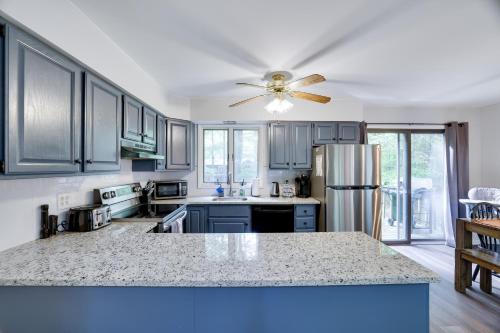 a kitchen with blue cabinets and a ceiling fan at Dreamy Lake House - Fireplace, Firepit & Pet Friendly in Pocono Lake