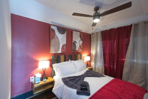 une chambre avec un lit avec un mur rouge dans l'établissement The Navel Nalle - Downtown Bungalow, Patio, Parking, à Charlottesville