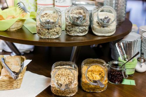 a table with four glass containers filled with food at Friesen Hotel in Jever
