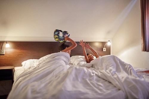 two people laying in bed with their hands in the air at Recreatiepark de Leistert in Roggel