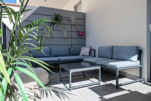 a blue couch and a table on a patio at Milanese LODGE/Luxury House in the heart of Milan in Milan