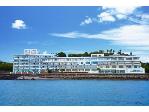 a large white building next to a body of water at Ibusuki Kaijo Hotel - Vacation STAY 87379v in Ibusuki