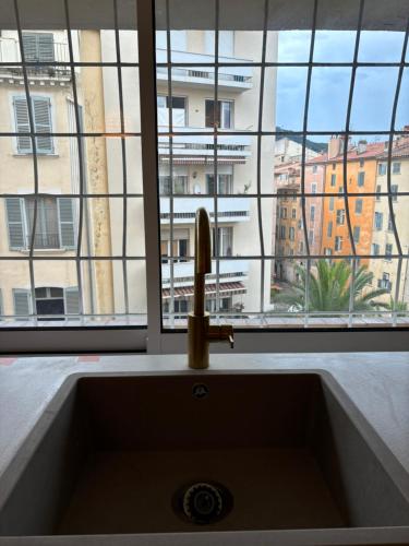 - un évier de cuisine avec vue sur le bâtiment dans l'établissement Escapade Méditerrannéenne Appart' Cosy et Élégant, à Toulon