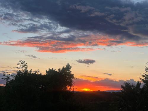 a sunset in the sky with trees in the foreground at Monte Paradiso Agriturismo in Pietralunga