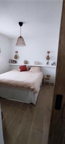 - une chambre blanche avec un lit et une lampe pendant dans l'établissement Résidence 1139-la Seyne Sur Mer - Magnifique maison moderne avec piscine dans un quartier typiquement provençale MAE-1431, à La Seyne-sur-Mer