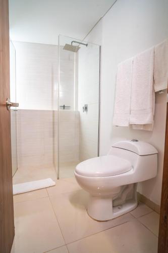 a white bathroom with a shower and a toilet at Ambar Hotel Boutique Cali in Cali