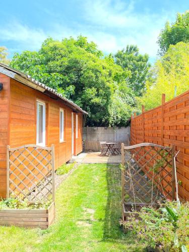une arrière-cour avec une clôture et une maison dans l'établissement Maisonnette en bois, à Le Perreux-Sur-Marne
